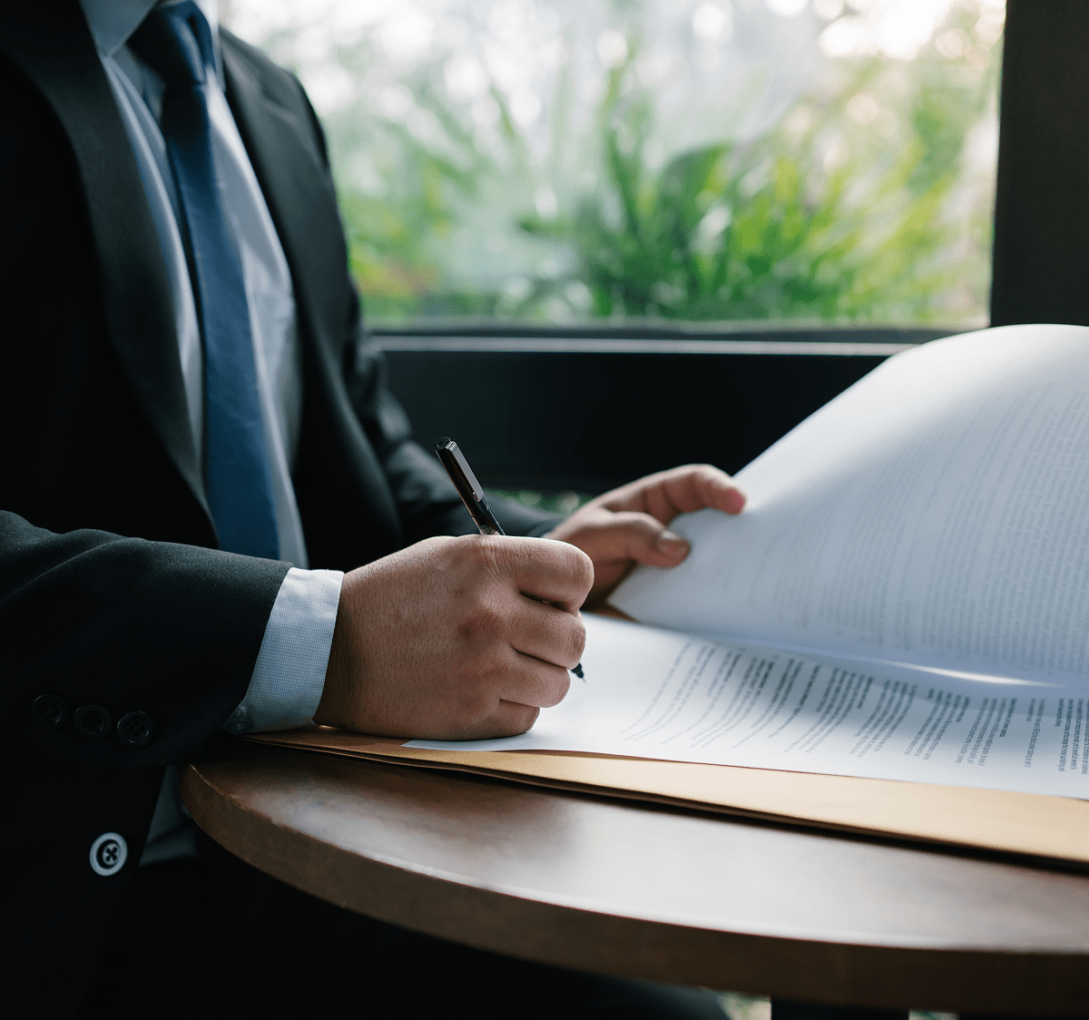 Man in suit writing on papers
